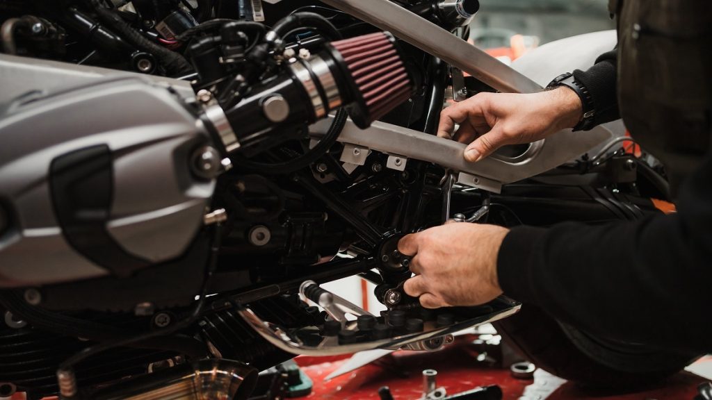 Man Fixing A Motorcycle In A Modern Workshop